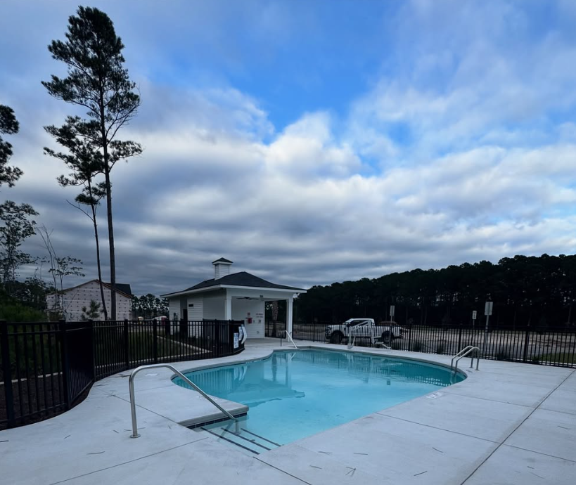 Finished resort-style pool with a white cupola pavilion and black aluminum fencing